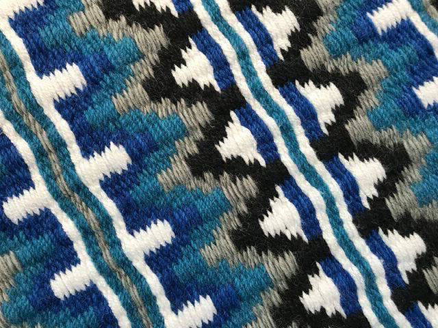 Close up of a custom Collection 33 Blue, Grey and White saddle blanket 