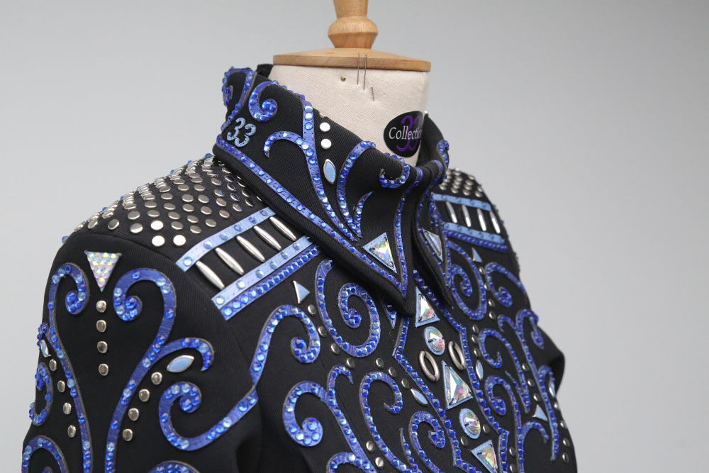 Close up of a custom Collection 33 Black based Horsemanship Top with Blue leather appliqué and stud and crystal detailing