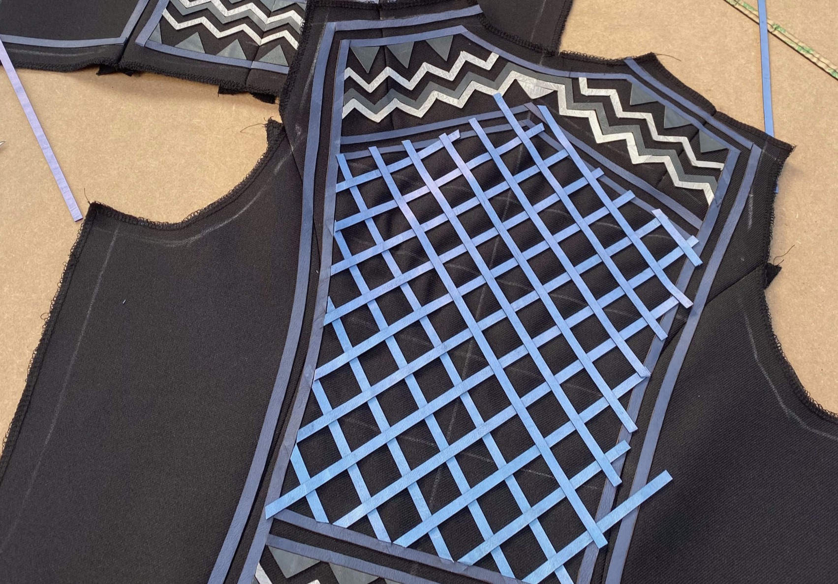 Close up of a custom Collection 33 Black based Riding Vest with Blue, Grey and Silver leather appliqué